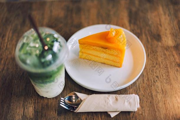 桔子蛋糕,<strong>冰</strong>冷的日本<strong>抹茶</strong>绿色的茶水拿铁咖啡和奶和勺向