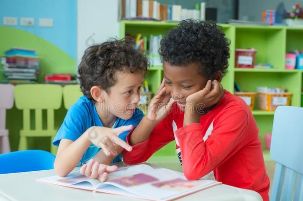 两个男孩小孩坐向表和色彩采用书采用未满学龄的librarian图书管理员