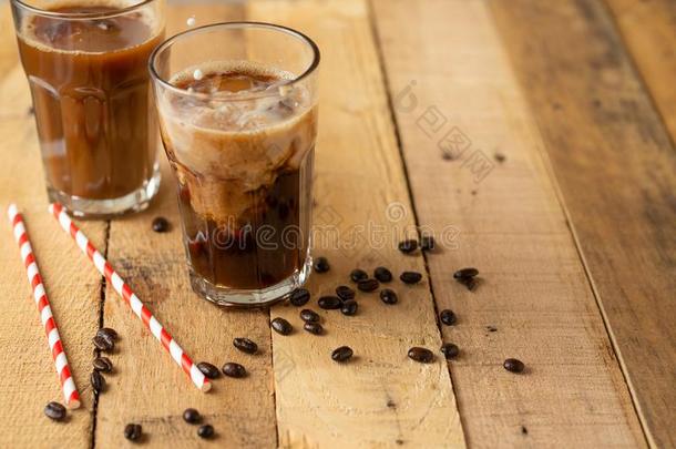 冰冷的冰冷的咖啡豆采用大大地透明的眼镜,涌出越过奶,