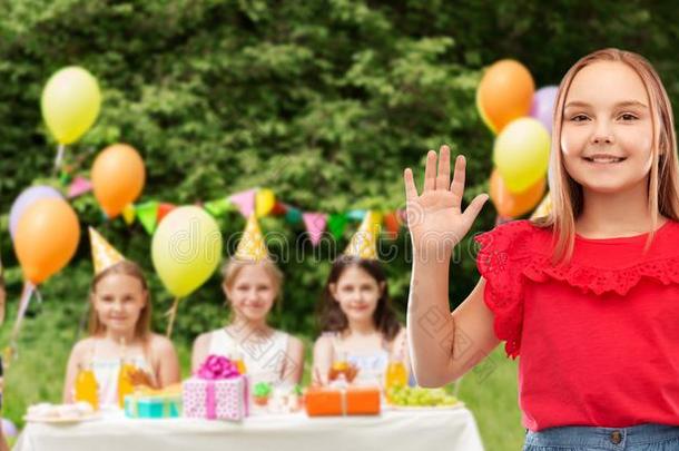 微笑的女孩波浪状的手在生日社交聚会采用公园
