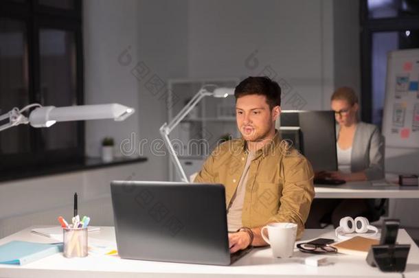 男人和计算机工作的晚的在夜办公室