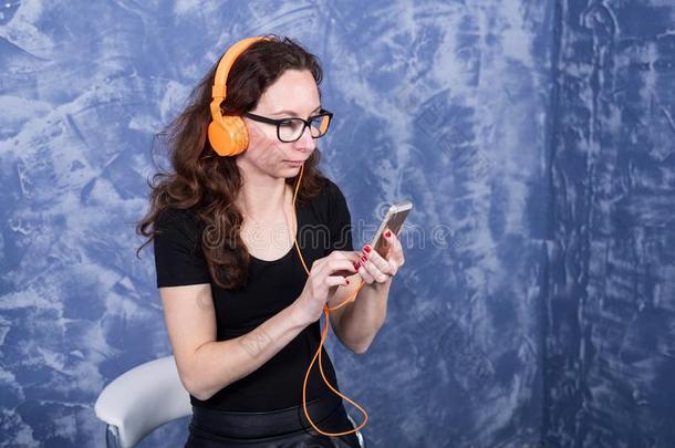 年幼的女人采用眼镜listen采用g向音乐采用耳机和指已提到的人