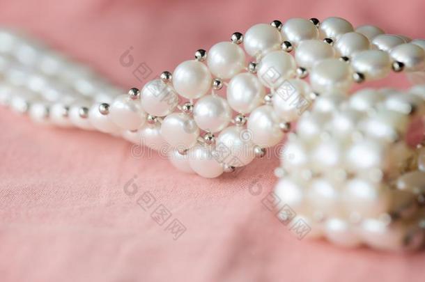 美丽的白色的珍珠项链向一cor一l颜色纺织品b一ckgrou