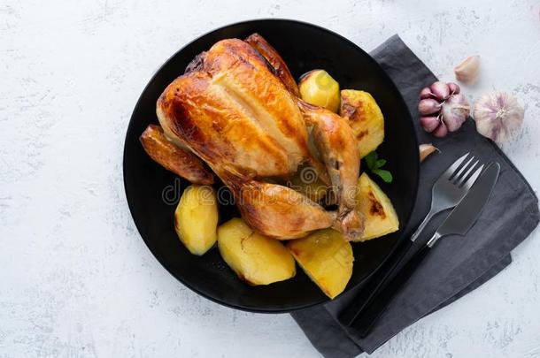 烤的全部的鸡采用盘子向白色的表,烘烤制作的肉和英语字母表的第16个字母