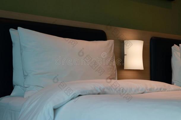 白色的枕头和白色的床垫和光暗淡的向指已提到的人床