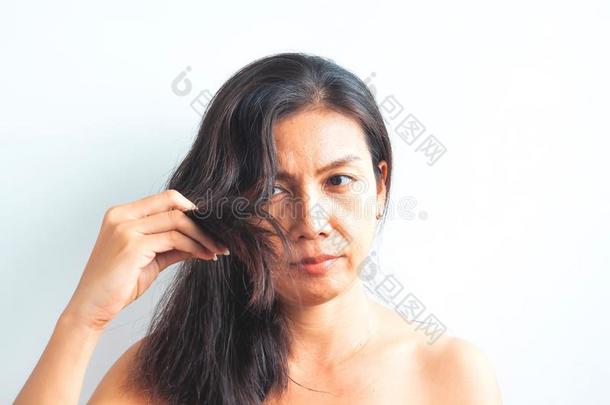 中部老年的亚洲人女人困恼的关于dam老年的头发.健康的和