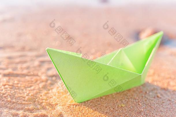 绿色的纸小船向沙的海滩在户外