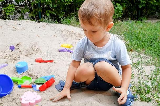 特写镜头照片关于3年老的蹒跚行走的人男孩演奏厚度玩具采用沙
