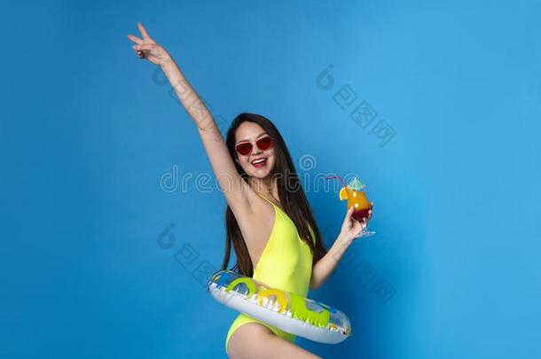 漂亮的女孩采用游泳衣和太阳镜Enjoy采用g热带的鸡尾酒