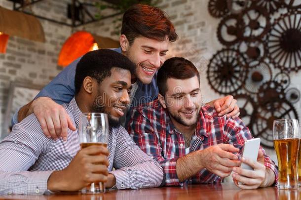 幸福的朋友观察磁带录像向智能手机和喝饮料啤酒