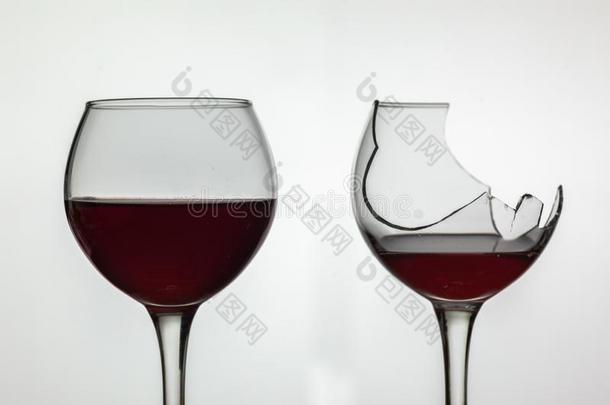 破碎的和不破碎的葡萄酒玻璃和红色的葡萄酒向白色的后台