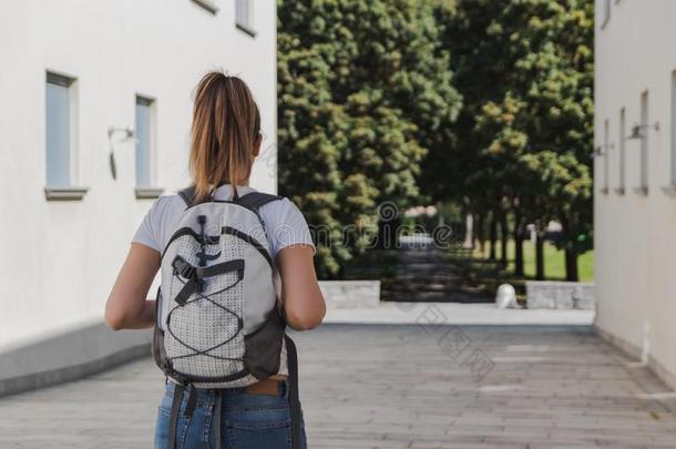 年幼的女人和背包步行向学校后的夏假日