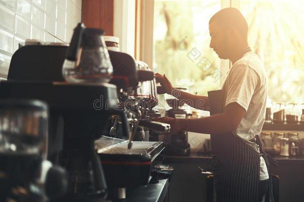 咖啡馆准备咖啡的员工准备卡普契诺咖啡采用他的咖啡豆商店