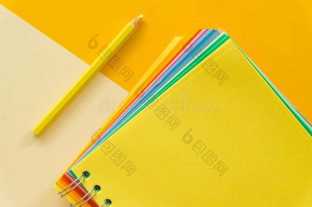 黄色的笔记簿向黄色的彩色粉笔粉红色的背景
