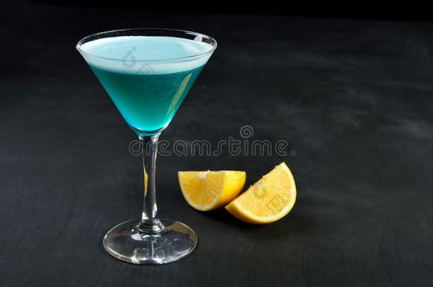 蓝色寒冷的鸡尾酒采用mart采用i玻璃和柠檬黑暗的背景