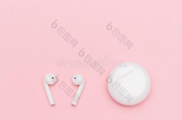 白色的不用电线的蓝牙耳机和装料例向粉红色的爸