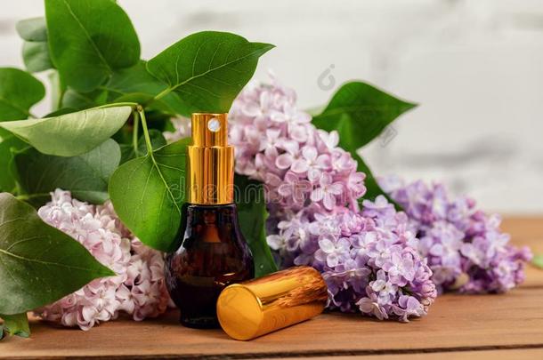 丁香花属香水-香味喷出水沫者和花向木制的表