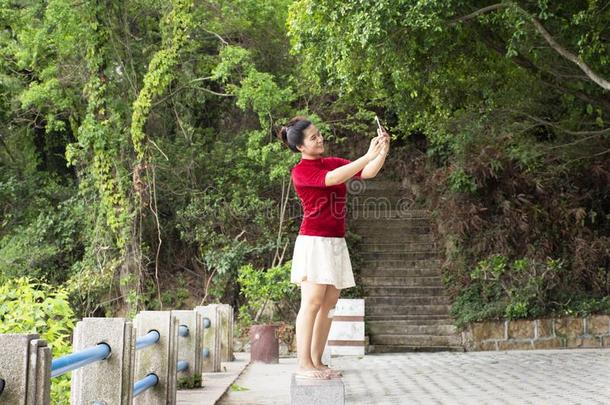 旅行支票ThaiAirwaysIntern在ional泰航<strong>国际</strong>女人使用智能<strong>手机</strong>自拍照拿照片在看法山芋食物