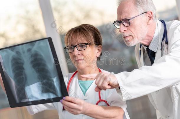 两个医生仔细检查字母x-射线报告