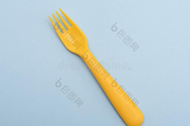 黄色的塑料制品餐叉向蓝色背景