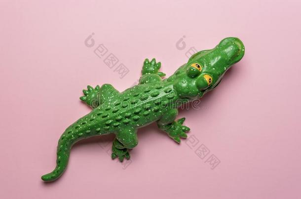 绿色的<strong>鳄鱼玩具</strong>向彩色粉笔粉红色的背景.最小的艺术c向ce