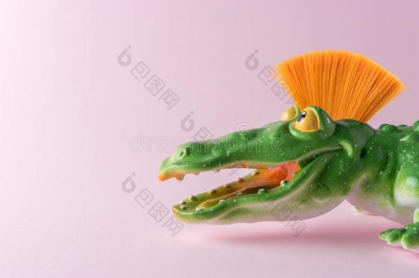 绿色的<strong>鳄鱼玩具</strong>和莫霍克人向彩色粉笔粉红色的背景.半音符