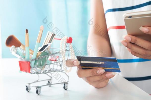 女人使用智能手机和信誉卡片购物美好物料项目.向
