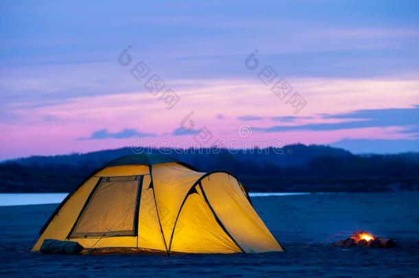 野营和黄色的帐篷在日出向一s一nd河b一nk