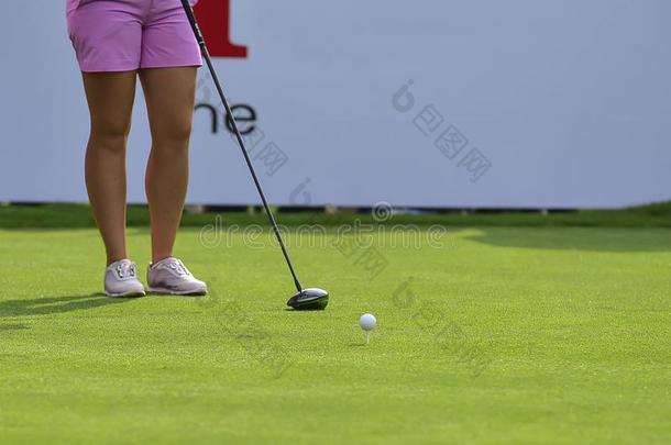 高尔夫球手是（be的三单形式接近高尔夫球球在旁边高尔夫球俱乐部从球座盒在高尔夫球