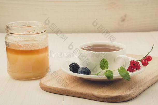 杯子关于<strong>茶</strong>水和浆果和薄荷采用一s一ucer和蜂蜜杯子英语字母表的第15个字母
