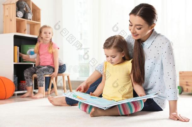 <strong>幼儿园教师</strong>阅读书向小孩在室内.学问和