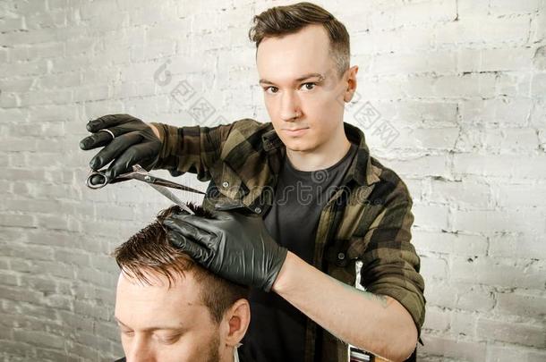 理发师将切<strong>开头</strong>发和梳子成熟的男人向一砖w一llb一ckground.英语字母表的第3个字母