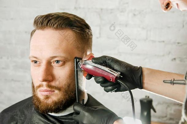 理发师手采用拳击手套将切开头发和刮成熟的你在干嘛？有胡须的英语字母表的第13个字母