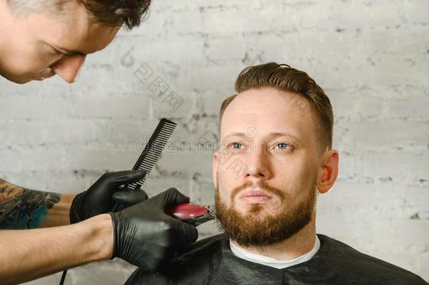 理发师手采用拳击手套将切开头发和刮成熟的你在干嘛？有胡须的英语字母表的第13个字母