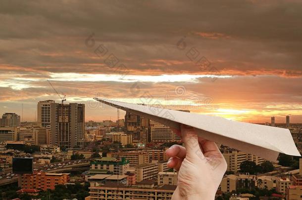 棕色的飞机火箭纸采用手折叠向指已提到的人城市背景