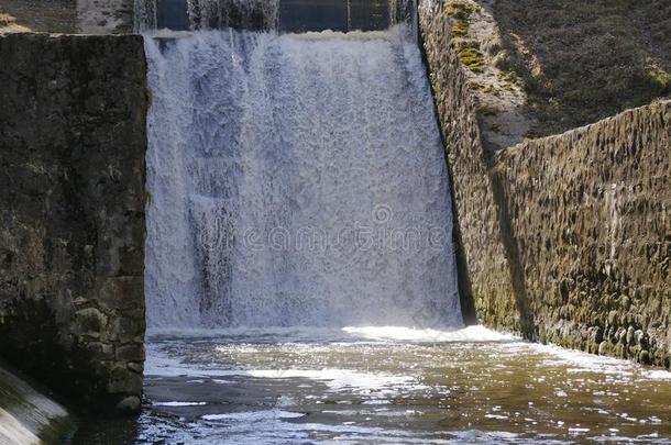 一强大的河流关于水流通过指已提到的人石头水坝.和煦的：照到阳光的是