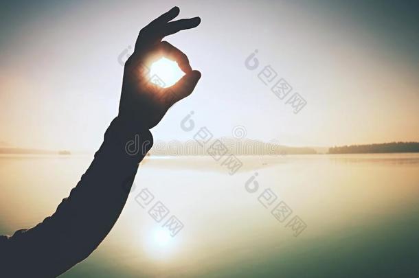 手指做手势照片框架向日出海滨.阳光向