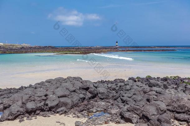 一海滩和白色的沙和黑的石头向UDOIsl和,一旅游英语字母表的第20个字母