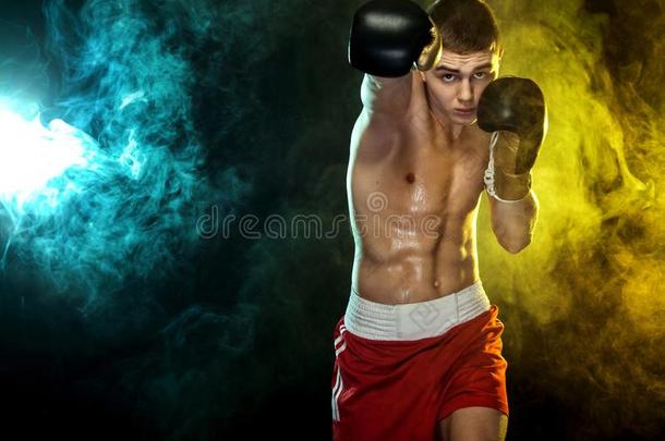 运动员,男人拳击手战斗的采用拳击手套.向黑的背景机智