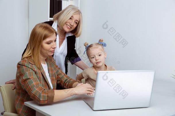 女孩维恩妈妈和gr和妈妈使用计算机同时.