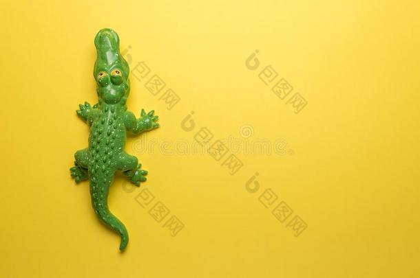 绿色的<strong>鳄鱼玩具</strong>向明亮的黄色的背景.最小的艺术c向