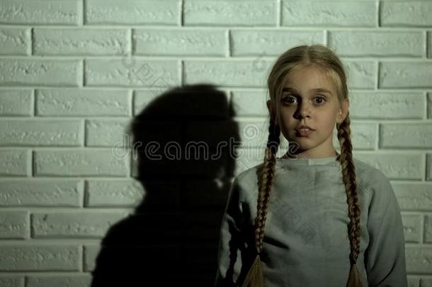害怕的小的女孩有样子的在照相机,诱拐或家庭的