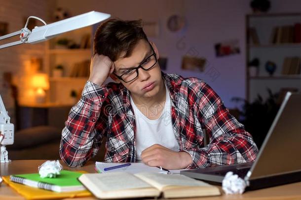 焦急的十几岁的青少年学生令人难于忍受的向解决困难的数学分配