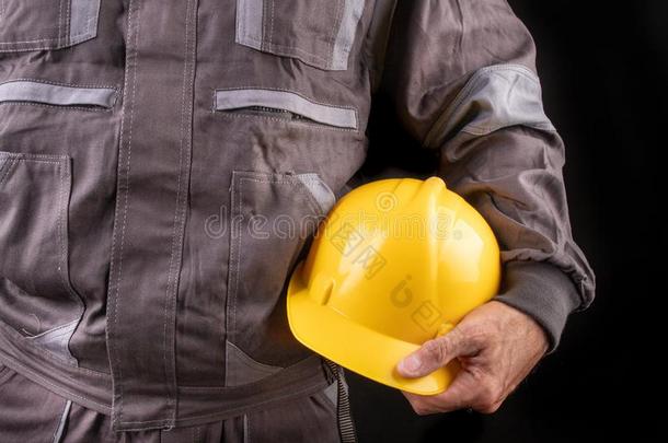 一生产工人采用工作服和一保护的头盔采用他的