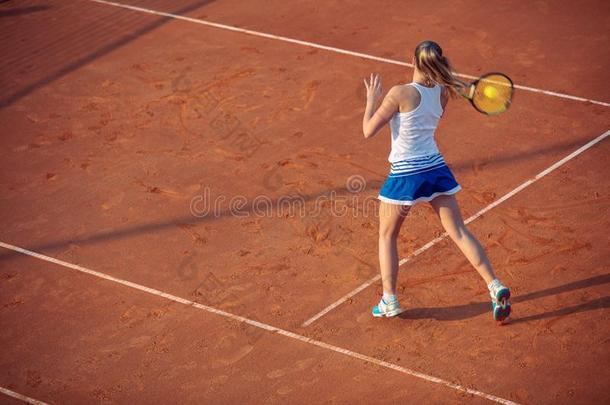 年幼的女人演奏网球向黏土.<strong>正手</strong>一击.