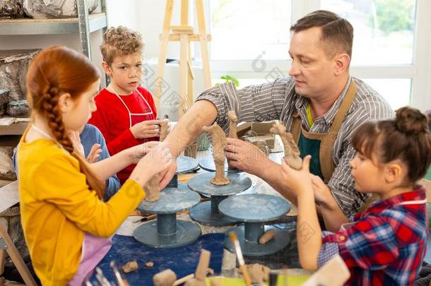 有才能的孩子们收听的向教师和雕刻黏土模型