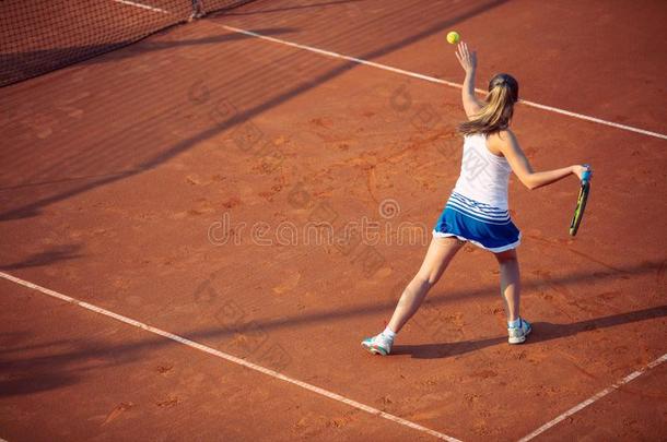 年幼的女人演奏网球向黏土.<strong>正手</strong>一击.