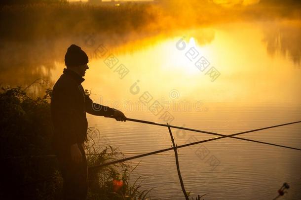 孤独的渔夫钓鱼在有雾的湖采用指已提到的人早的morn采用g刚才