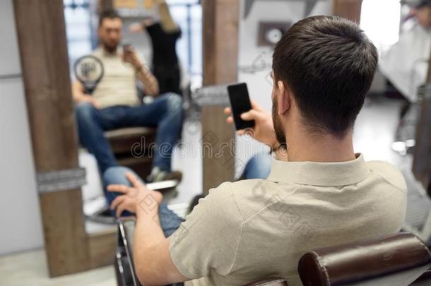 男人和智能手机在<strong>理发店</strong>或头发沙龙