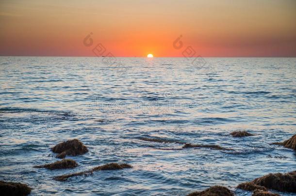 日落风景和金色的太阳和石头在海